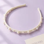 Smal hårbøjle Pearl Dot på ensfarvet baggrund