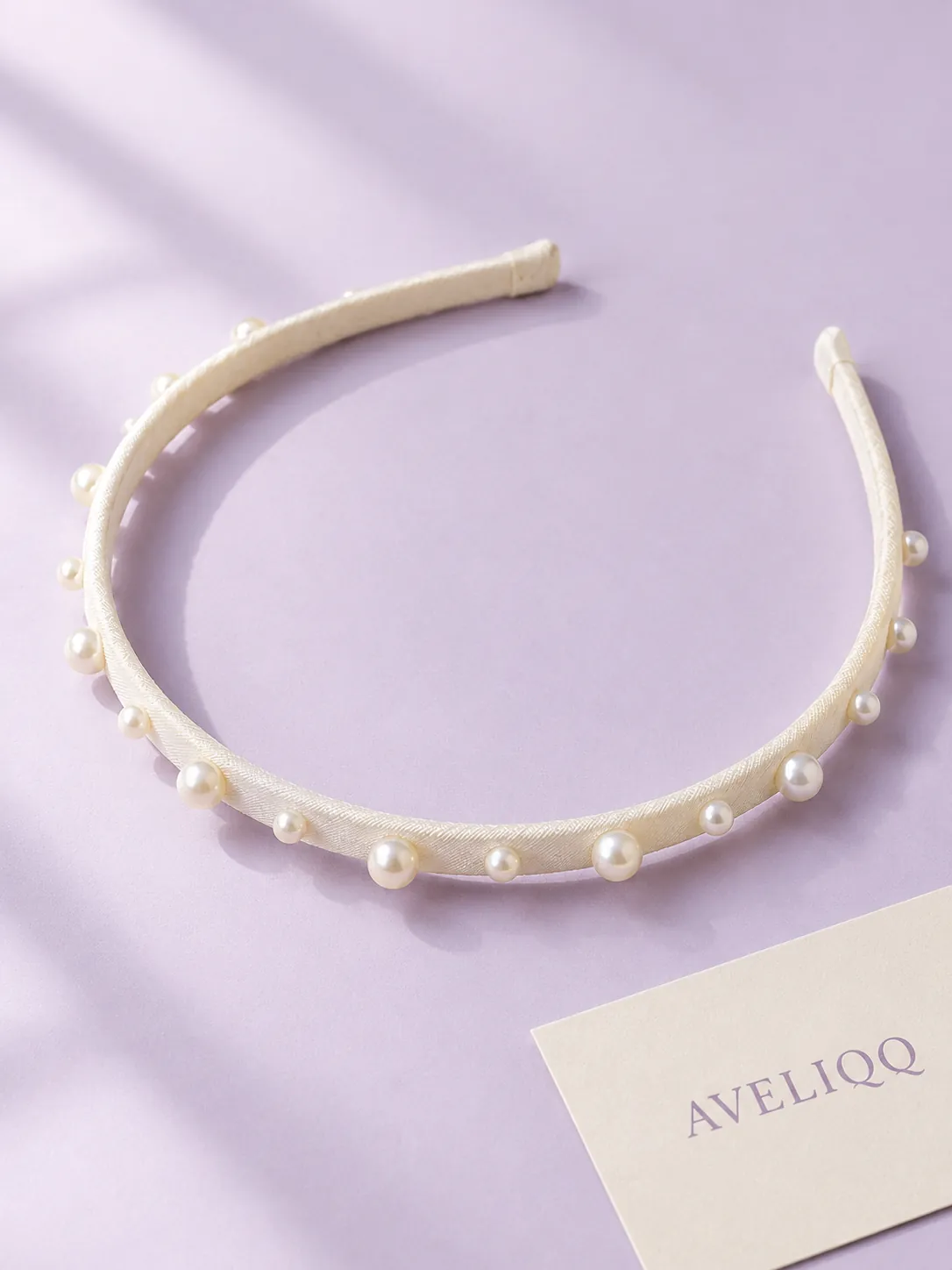Smal hårbøjle Pearl Dot på ensfarvet baggrund